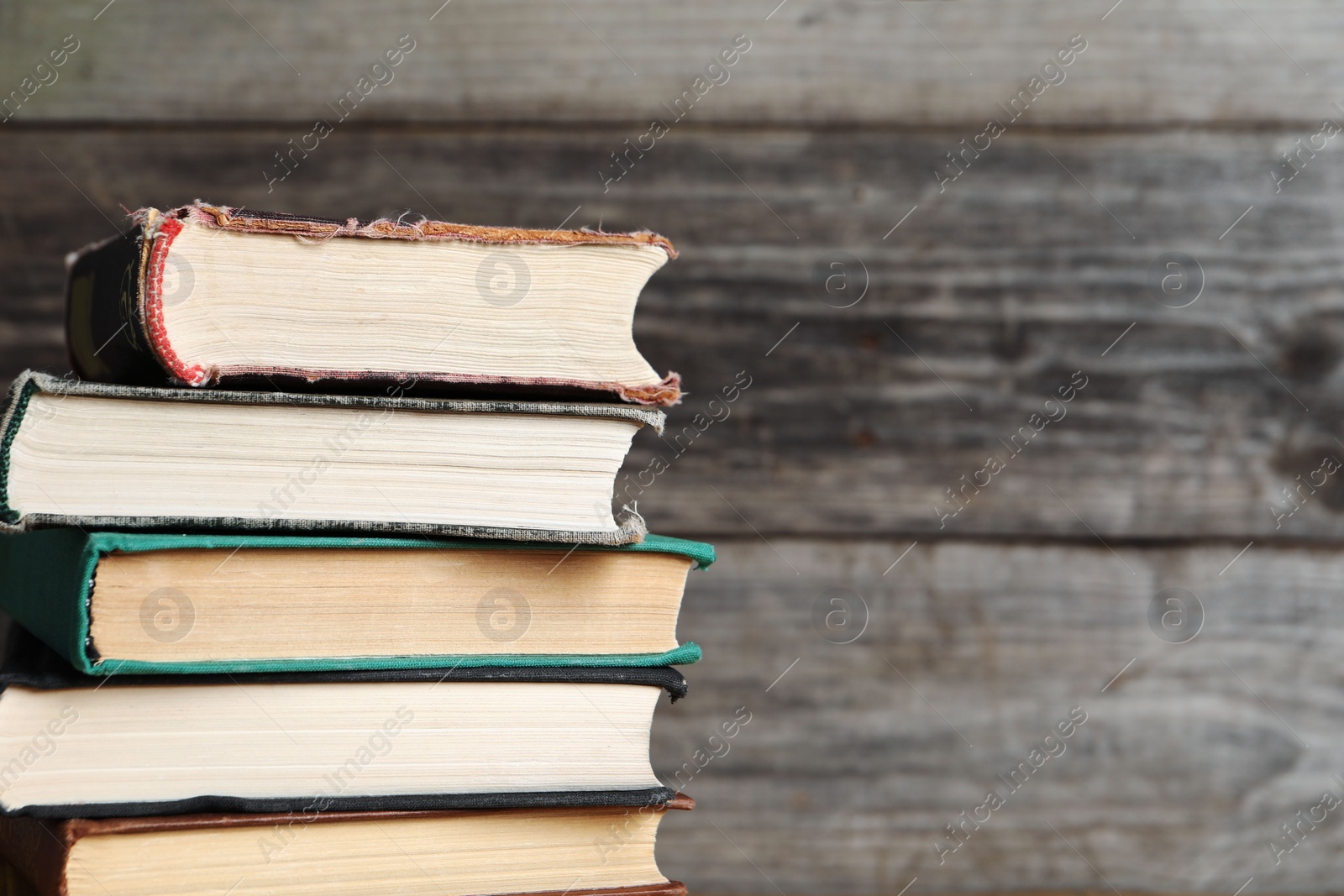 Photo of Stack of old hardcover books on wooden background, closeup. Space for text