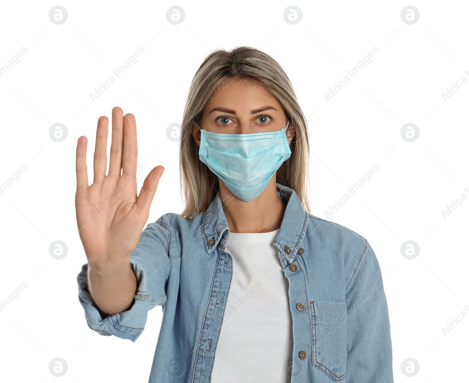 Photo of Woman in protective mask showing stop gesture on white background. Prevent spreading of coronavirus