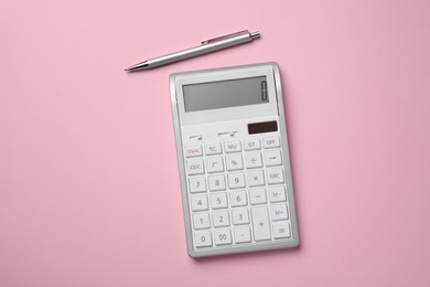 Calculator and pen on pink background, flat lay