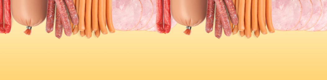 Many different tasty sausages on yellow background, flat lay. Banner design