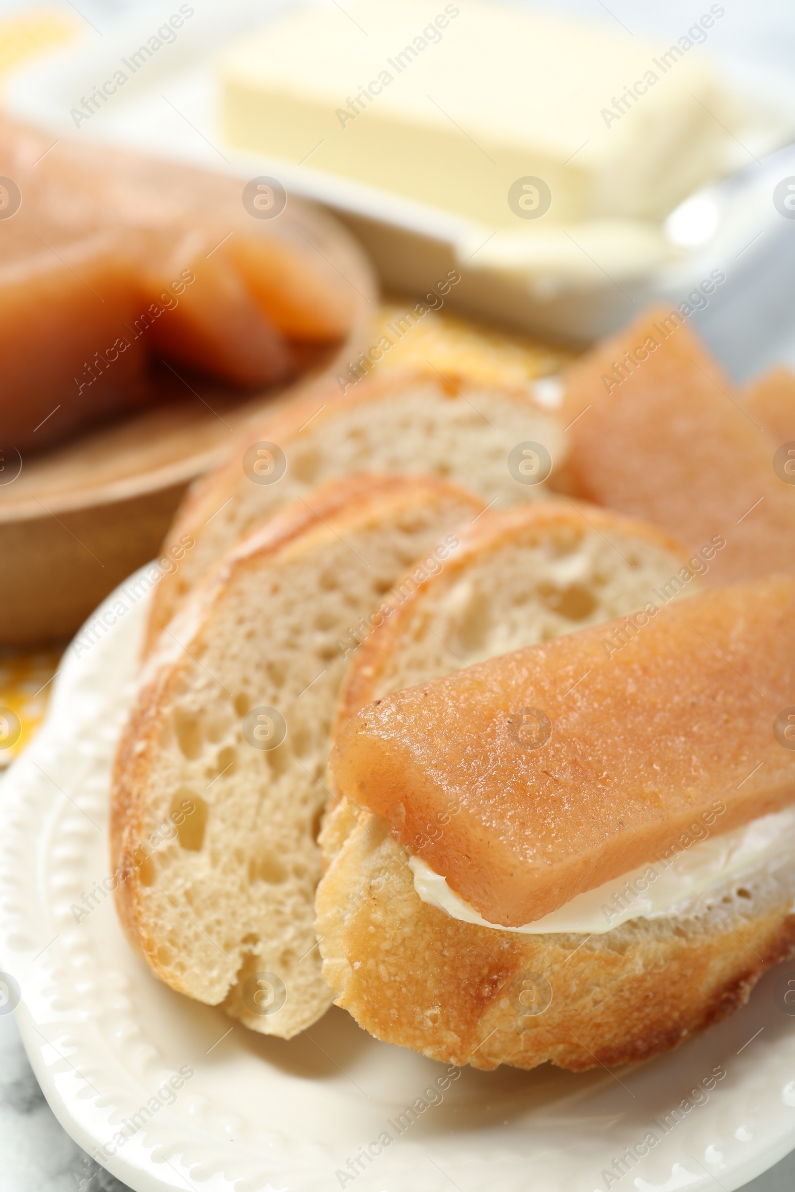 Photo of Delicious quince paste and bread on table, closeup