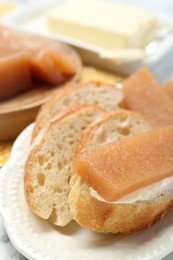Photo of Delicious quince paste and bread on table, closeup