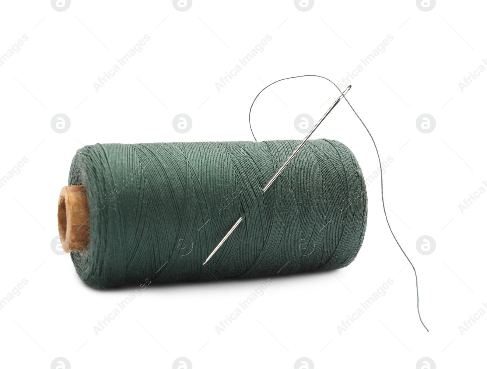Photo of Green sewing thread with needle on white background