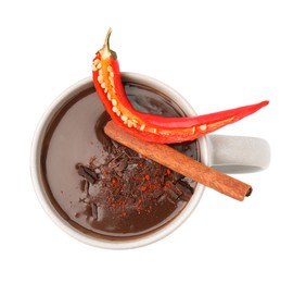Cup of hot chocolate with chili pepper and cinnamon on white background, top view