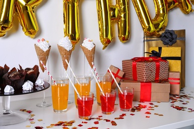 Photo of Treats and gifts on table in room decorated for birthday party