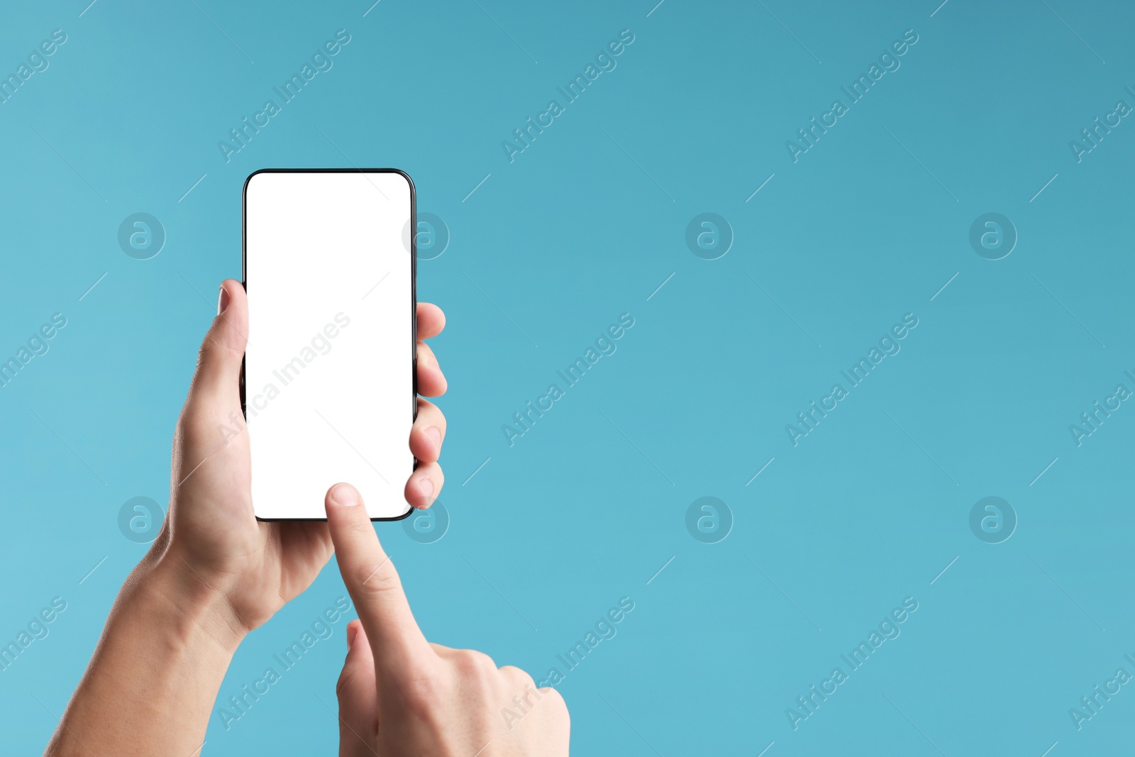 Photo of Man using smartphone with blank screen on light blue background, closeup. Mockup for design