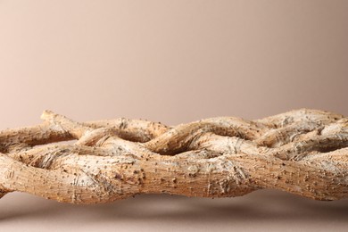 Photo of Presentation for product. Braided tree trunk on beige background. Space for text