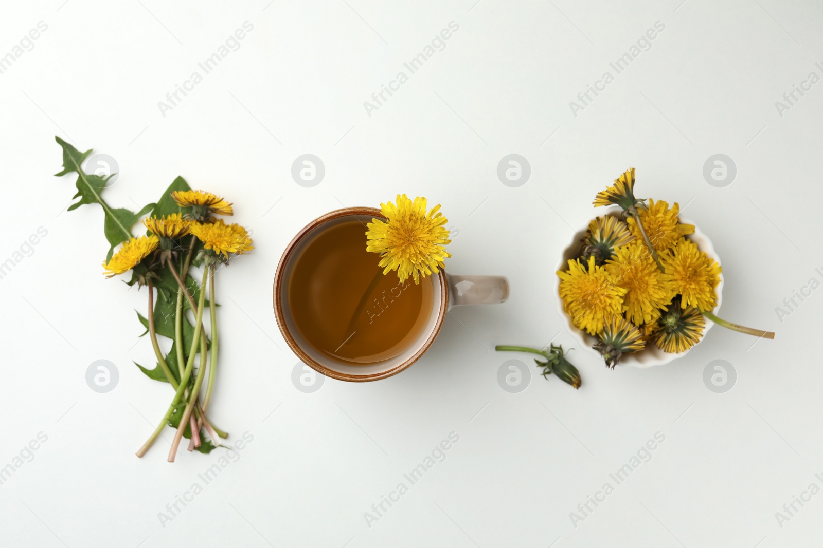 Photo of Delicious fresh tea and beautiful dandelion flowers on white background, top view