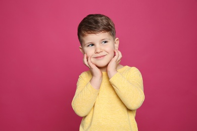 Photo of Portrait of little boy laughing on color background