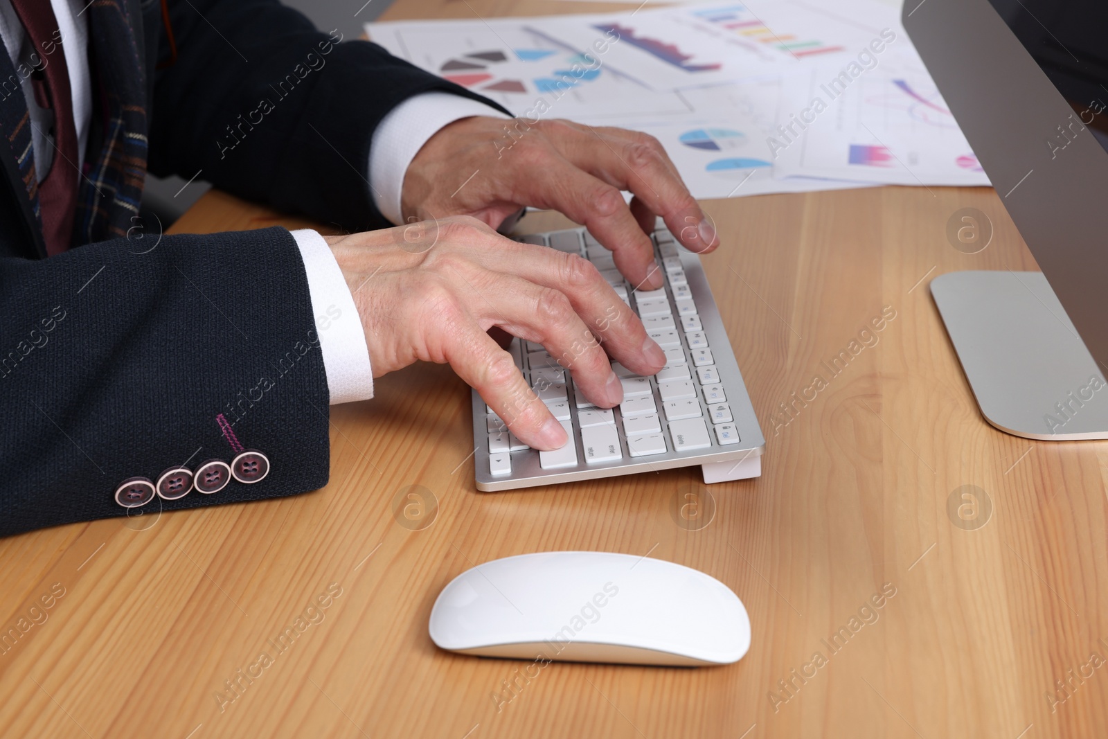 Photo of Boss working on computer at wooden table in office, closeup