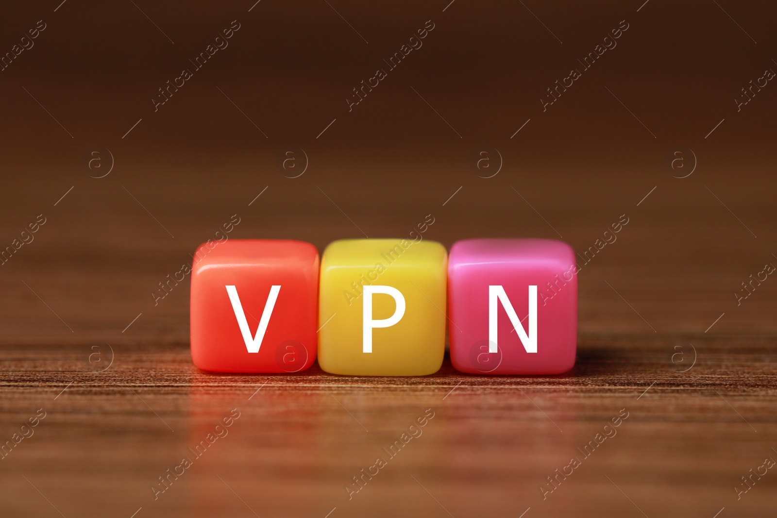 Photo of Colorful plastic beads with acronym VPN on wooden table