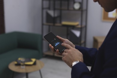 Businessman working with smartphone in office, closeup. Forex trading