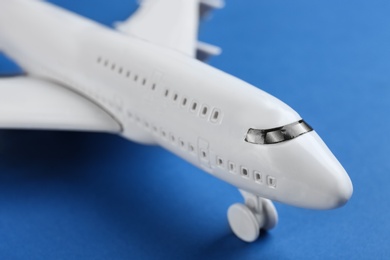 Toy airplane on blue background, closeup view