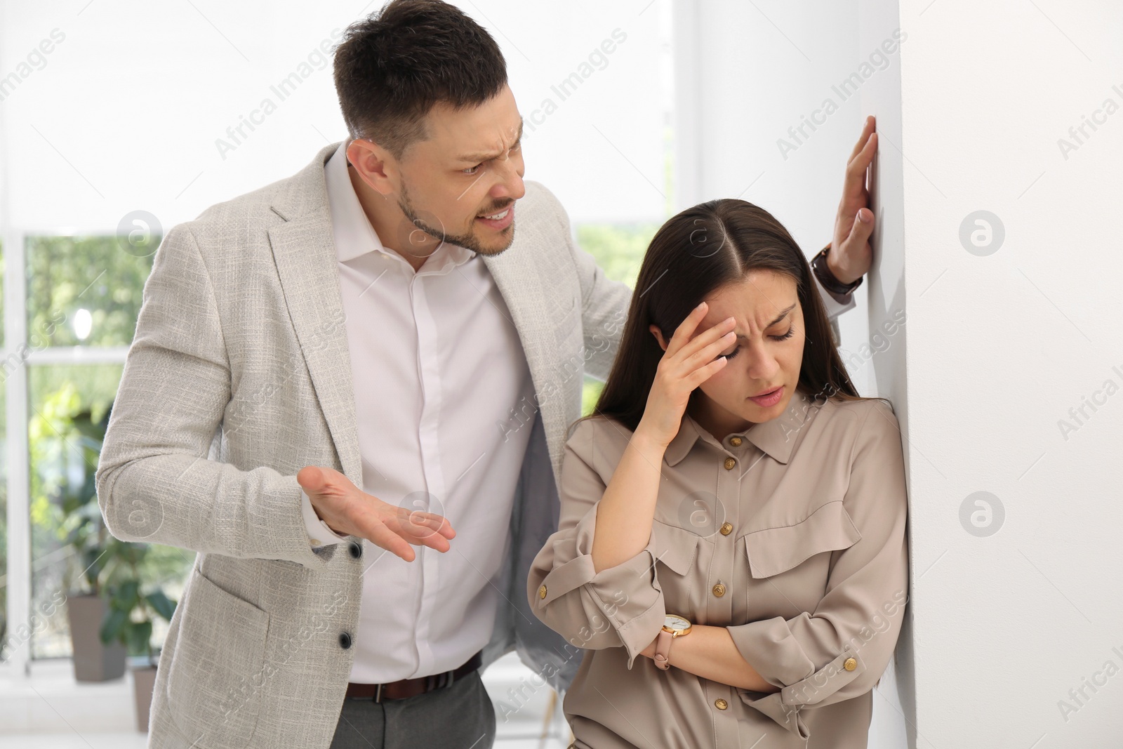 Photo of Man screaming at woman in office. Toxic work environment