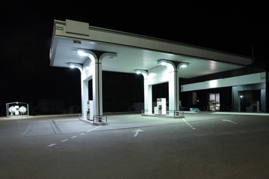 Photo of Modern gas station with convenience store beside the road at night