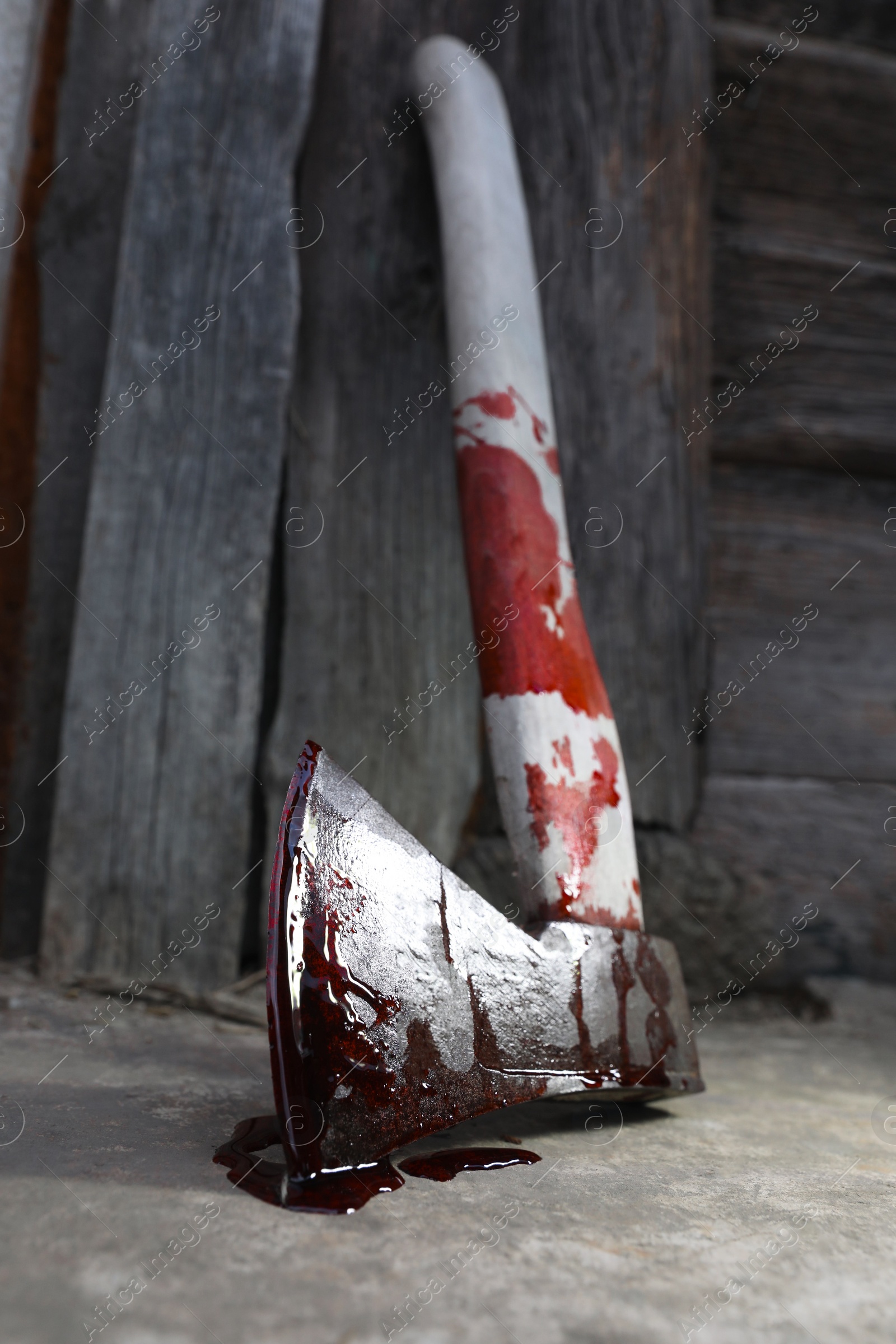 Photo of Axe with blood on floor indoors, closeup