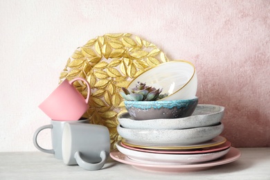 Photo of Set of dinnerware on table against color background. Interior element