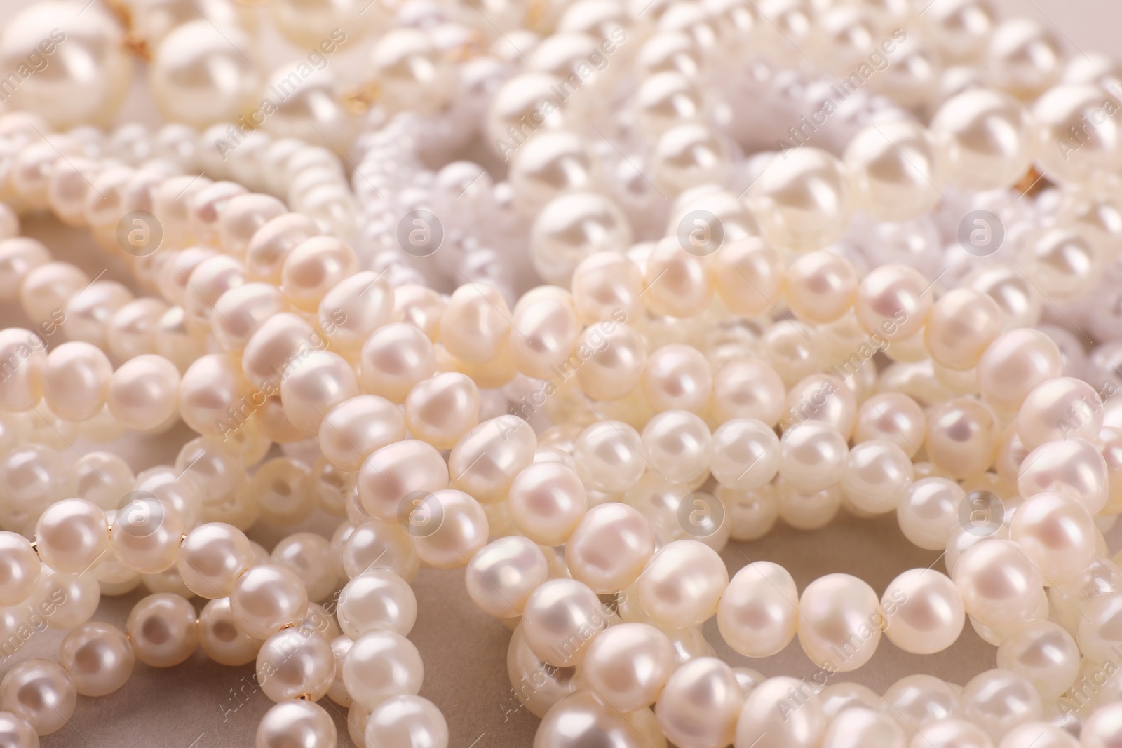 Photo of Elegant pearl necklaces as background, closeup view