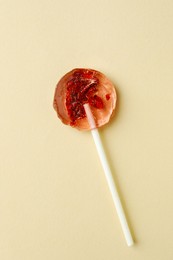 Photo of Sweet colorful lollipop with berries on beige background, top view