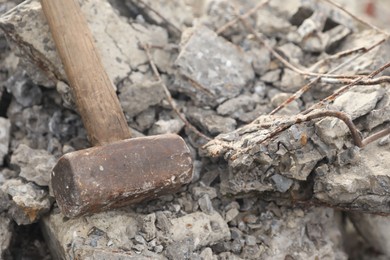 Photo of Sledgehammer on pile of broken stones outdoors, closeup