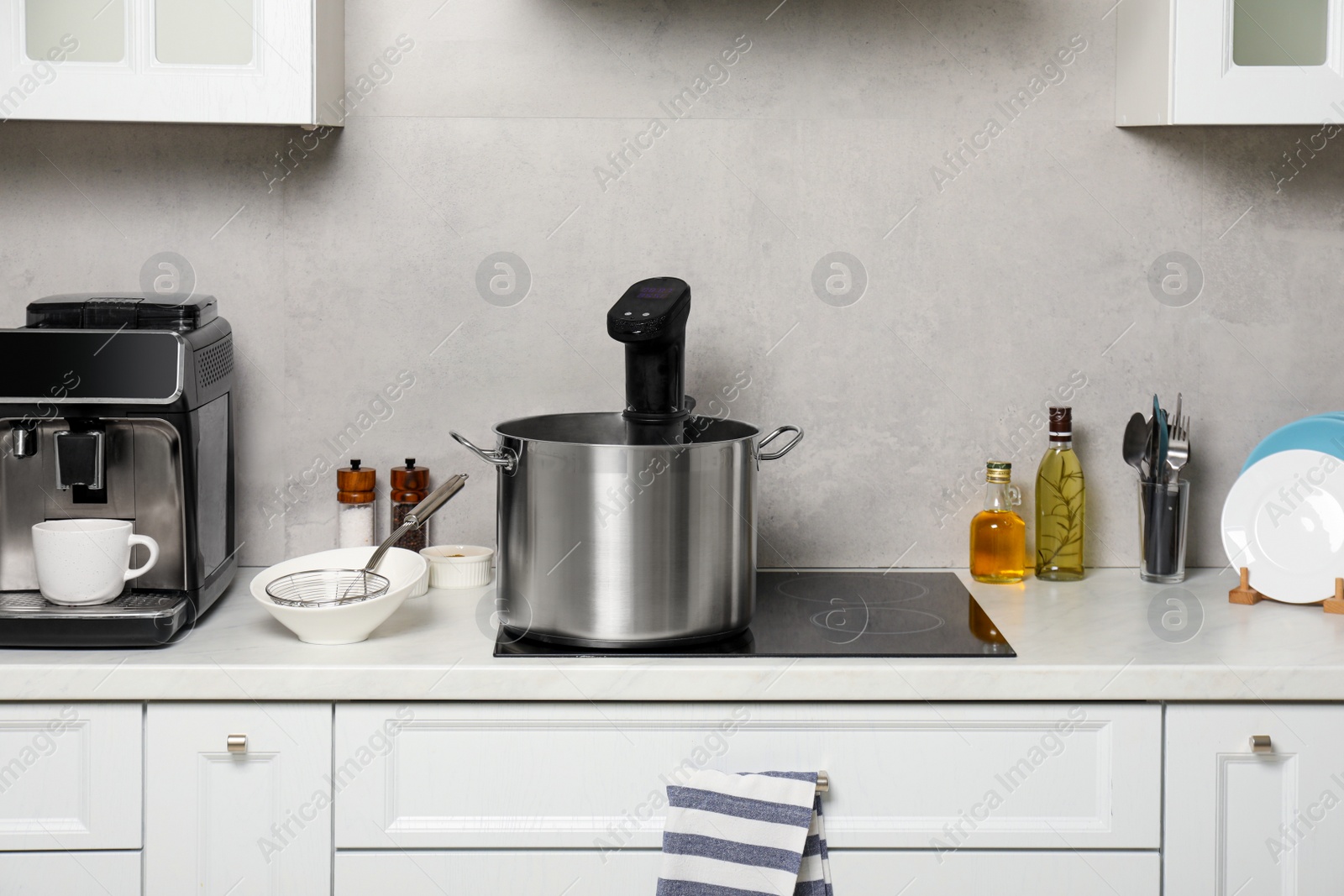 Photo of Pot with sous vide cooker in kitchen. Thermal immersion circulator