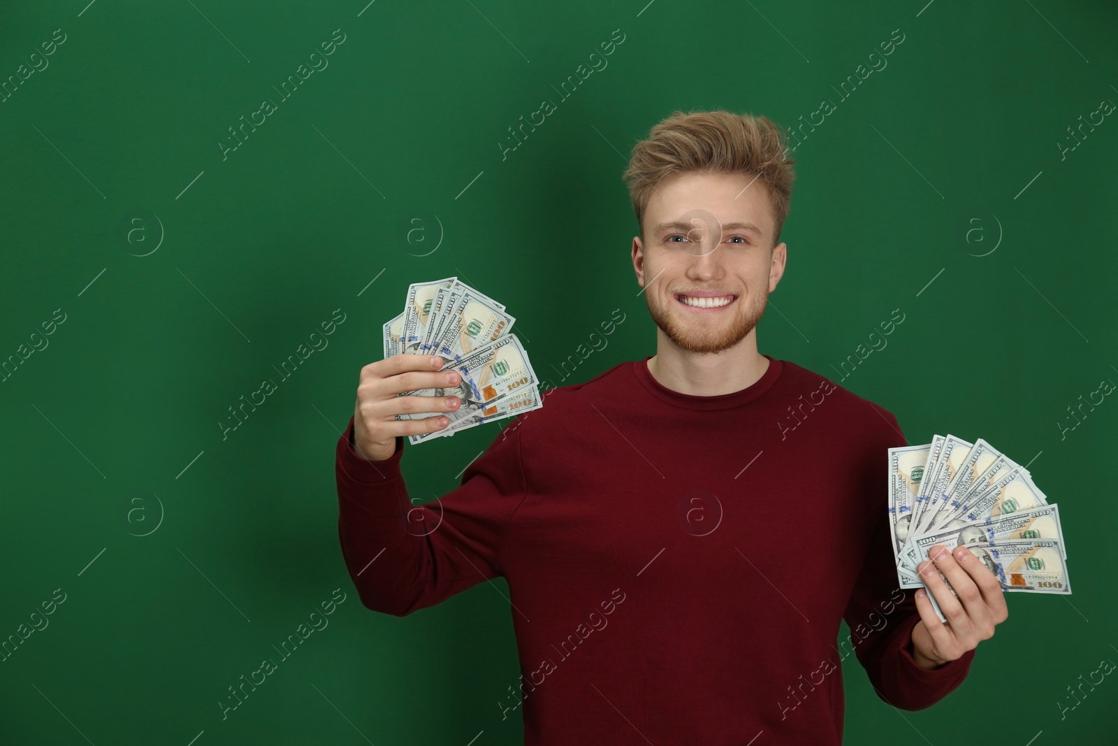 Photo of Young man with money on color background. Space for text