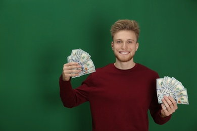 Young man with money on color background. Space for text