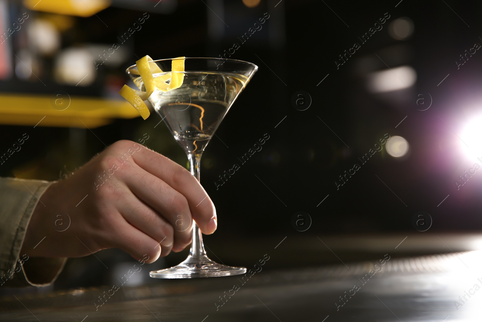 Photo of Barman with glass of lemon drop martini cocktail in pub, closeup. Space for text