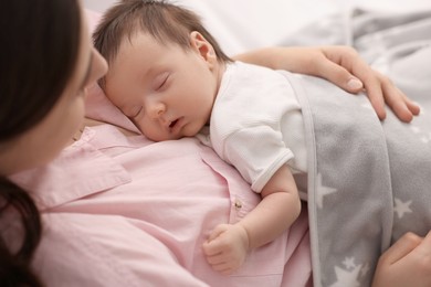 Photo of Mother with her sleeping newborn baby in bed, closeup