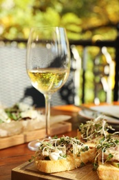 Photo of Delicious bruschettas with fish on wooden table