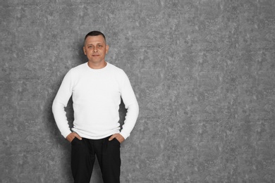 Photo of Portrait of mature man on grey background. Space for text