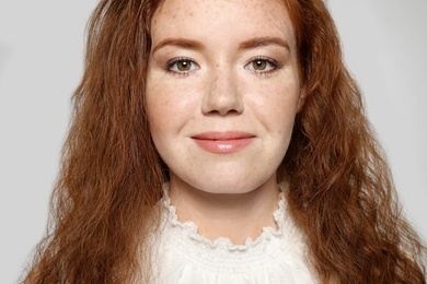 Portrait of young woman with beautiful face on grey background, closeup