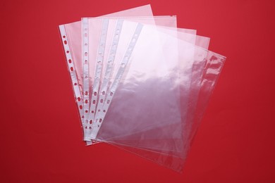 Photo of Empty punched pockets on red background, flat lay