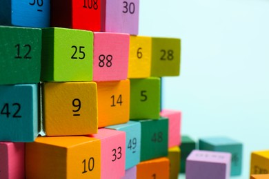 Photo of Wooden cubes with different numbers on light background, closeup. Space for text