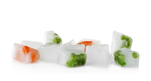 Photo of Fresh vegetables frozen in ice cubes on white background