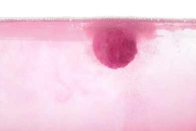 Photo of Pink bath bomb in water on white background