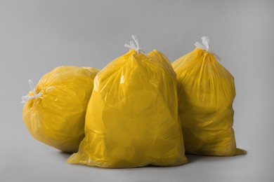 Photo of Trash bags full of garbage on grey background