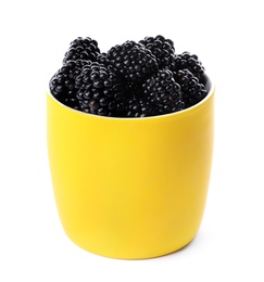 Yellow cup of tasty blackberries on white background