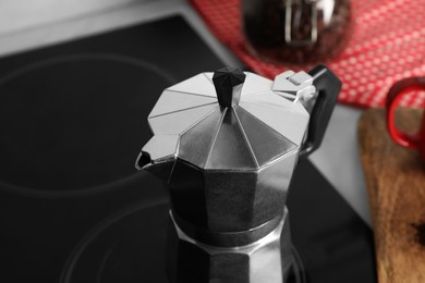 Photo of Brewing coffee. Metal moka pot on stove, closeup