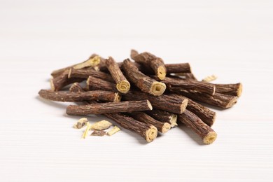Dried sticks of liquorice root on white wooden table