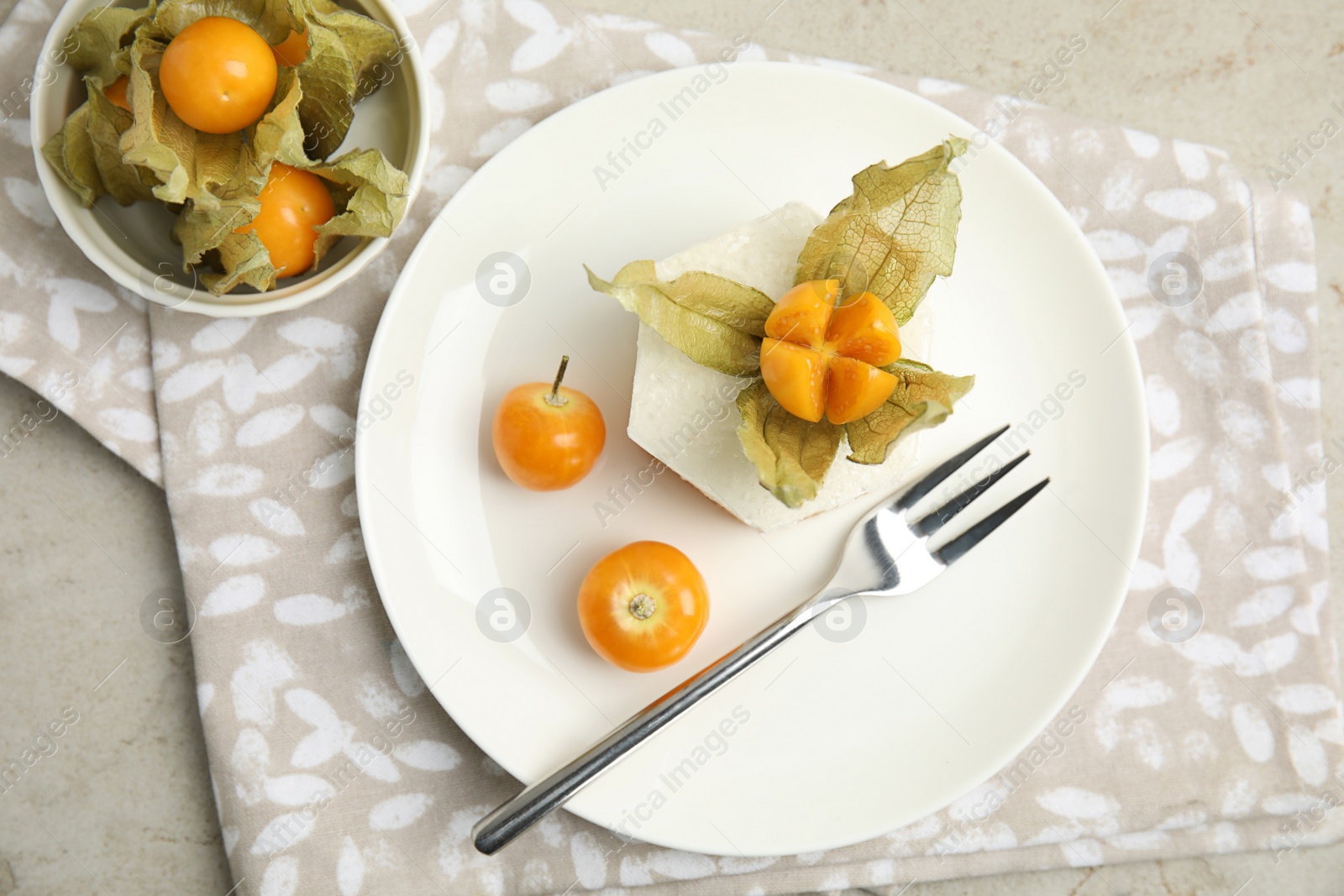 Photo of Delicious dessert decorated with physalis on grey table, flat lay