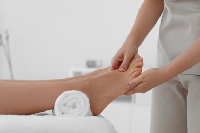 Photo of Woman receiving foot massage in wellness center, closeup