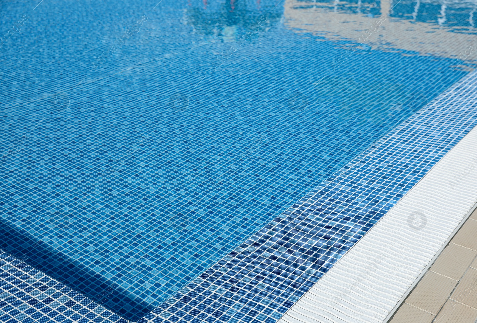 Photo of Outdoor swimming pool with clear water on sunny day. Summer vacation