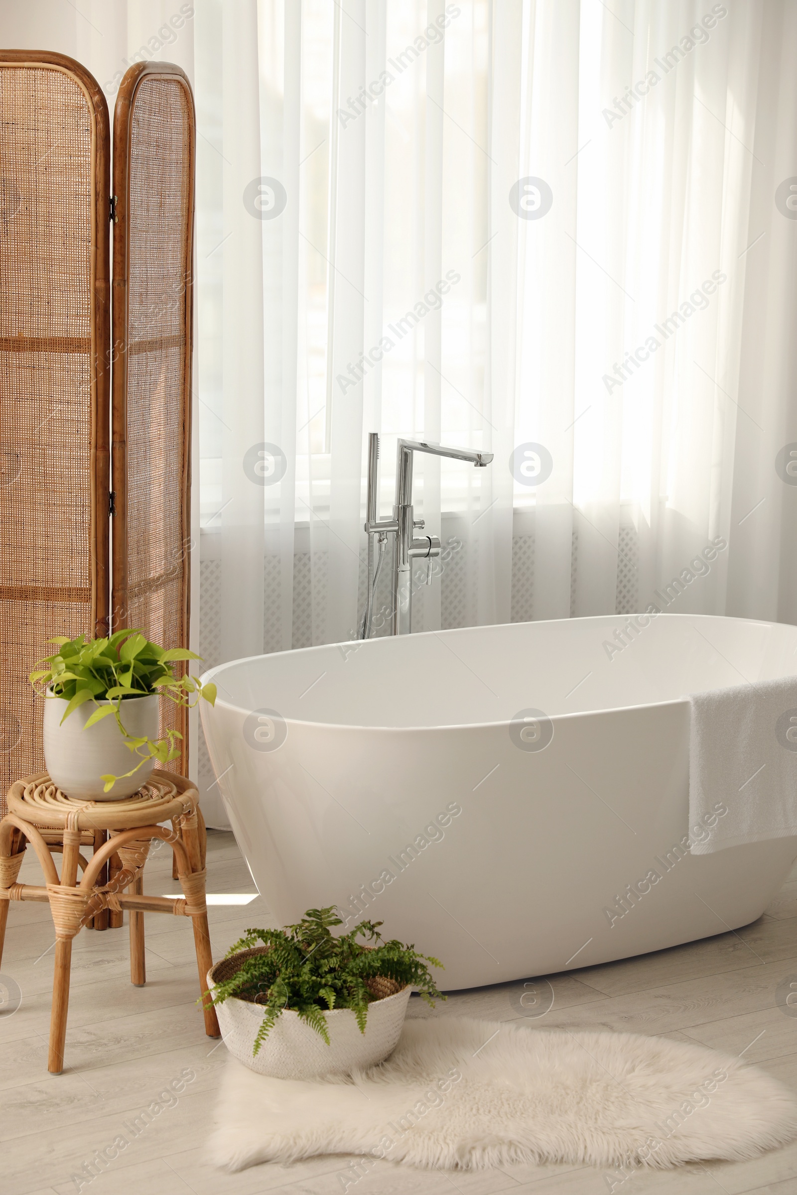 Photo of White tub near window in light room. Interior design