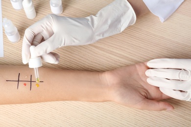 Doctor making allergy test at table, top view