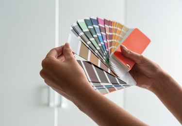 Female interior designer with color palette samples indoors, closeup