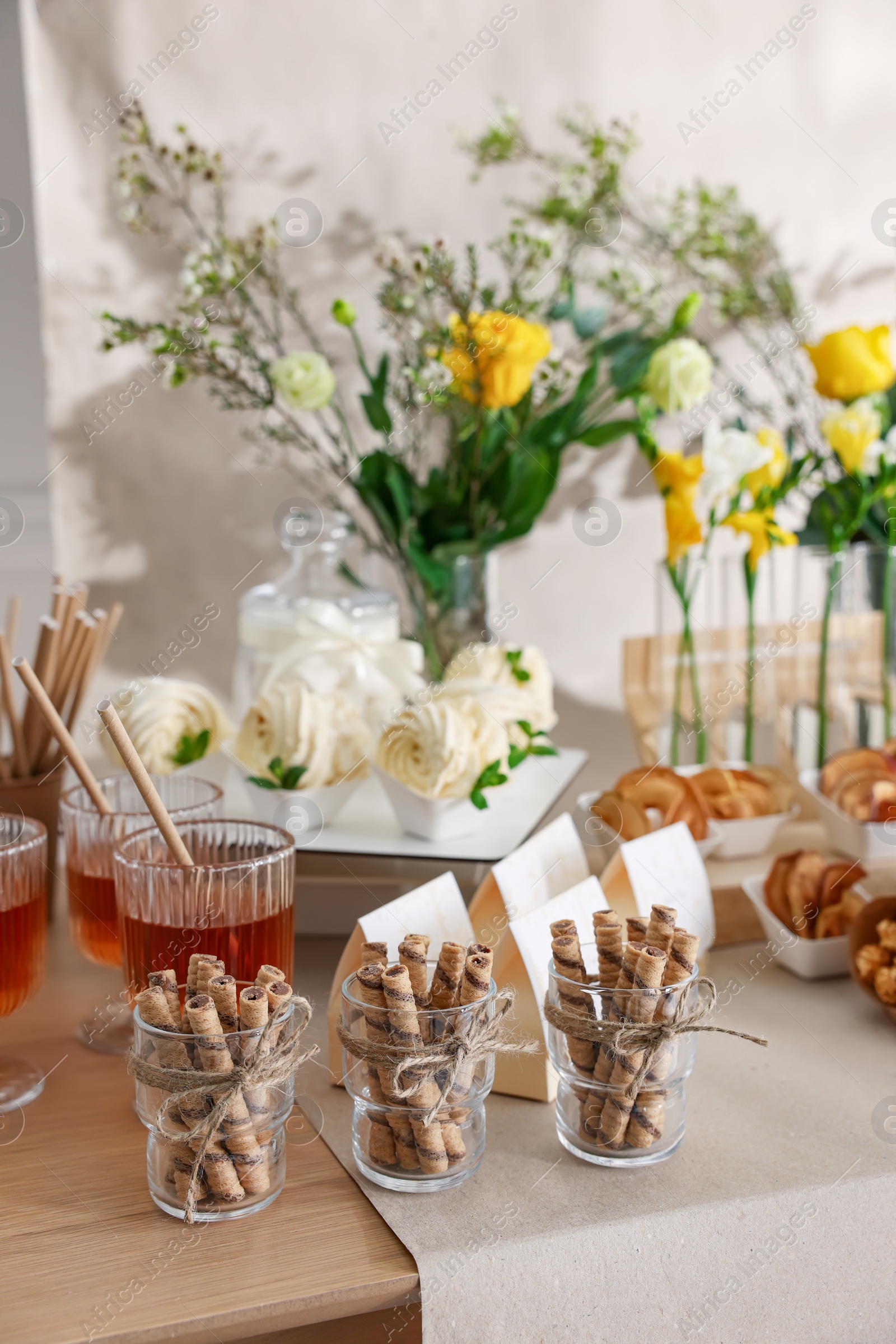 Photo of Delicious treats on wooden table in room. Sweet buffet