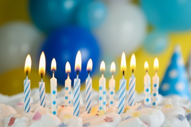 Photo of Birthday cake with burning candles on blurred background, closeup