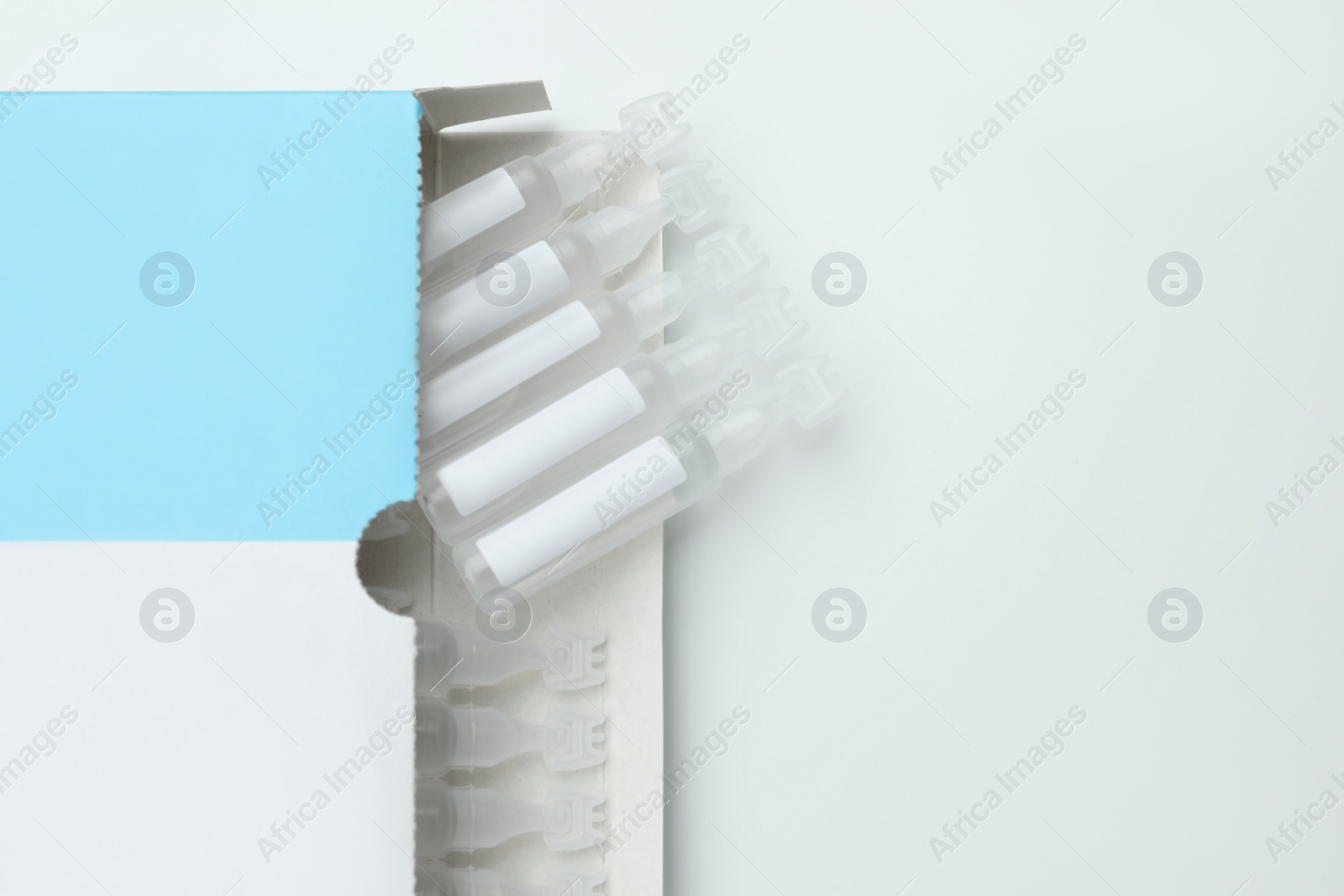 Photo of Package with single dose ampoules of sterile isotonic sea water solution on white background, top view. Space for text