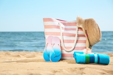 Stylish beach accessories on sand near sea. Space for text